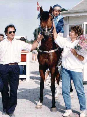 Tränaren John Huber, jockeyn Janos Tandari, ägaren Katarina Törngård och Elcatero ox (e. Eldorado – ue. Grojor) efter ett segerlopp i Köpenhamn. Klicka här för att komma till Tjust Arabers webbsida.